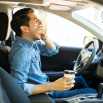 Man yawning while driving car